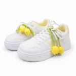 Side view of girls premium white shoes with yellow gingham laces and floral design.