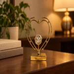 Gold double heart crystal ball decorative showpiece on walnut shelf